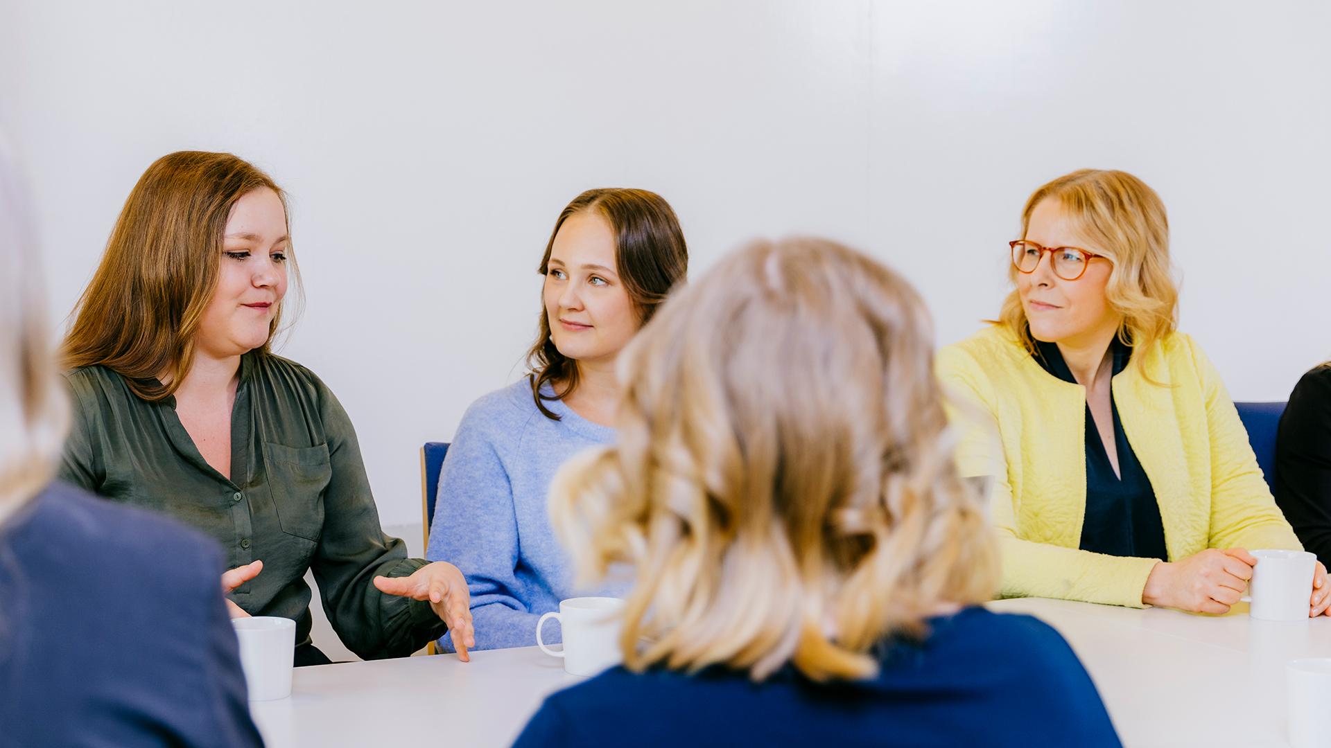 En grupp av kvinnor sitter vid konferensbordet.