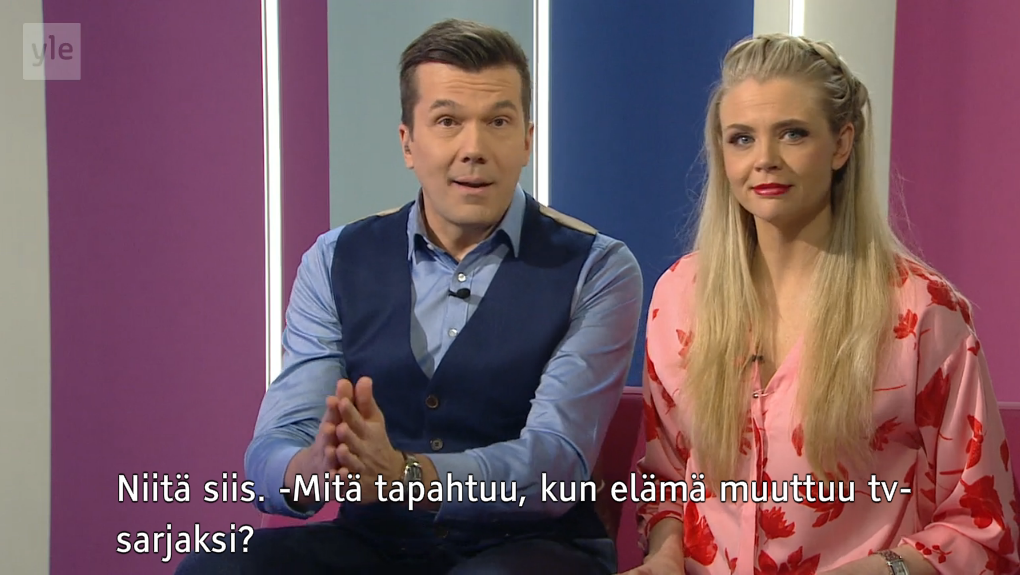 Screenshot from Yle's tv program Puoli seitsemän with two hosts sitting in a studio. At the lower part of the picture is the subtitling that says "What happens when life turns into a tv series?"